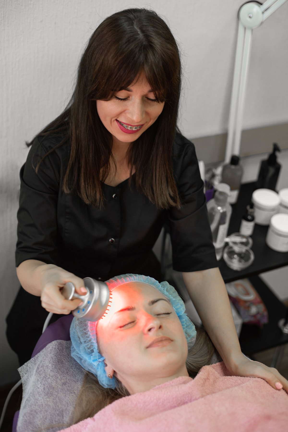 Profissional realizando terapia facial com tecnologia estética