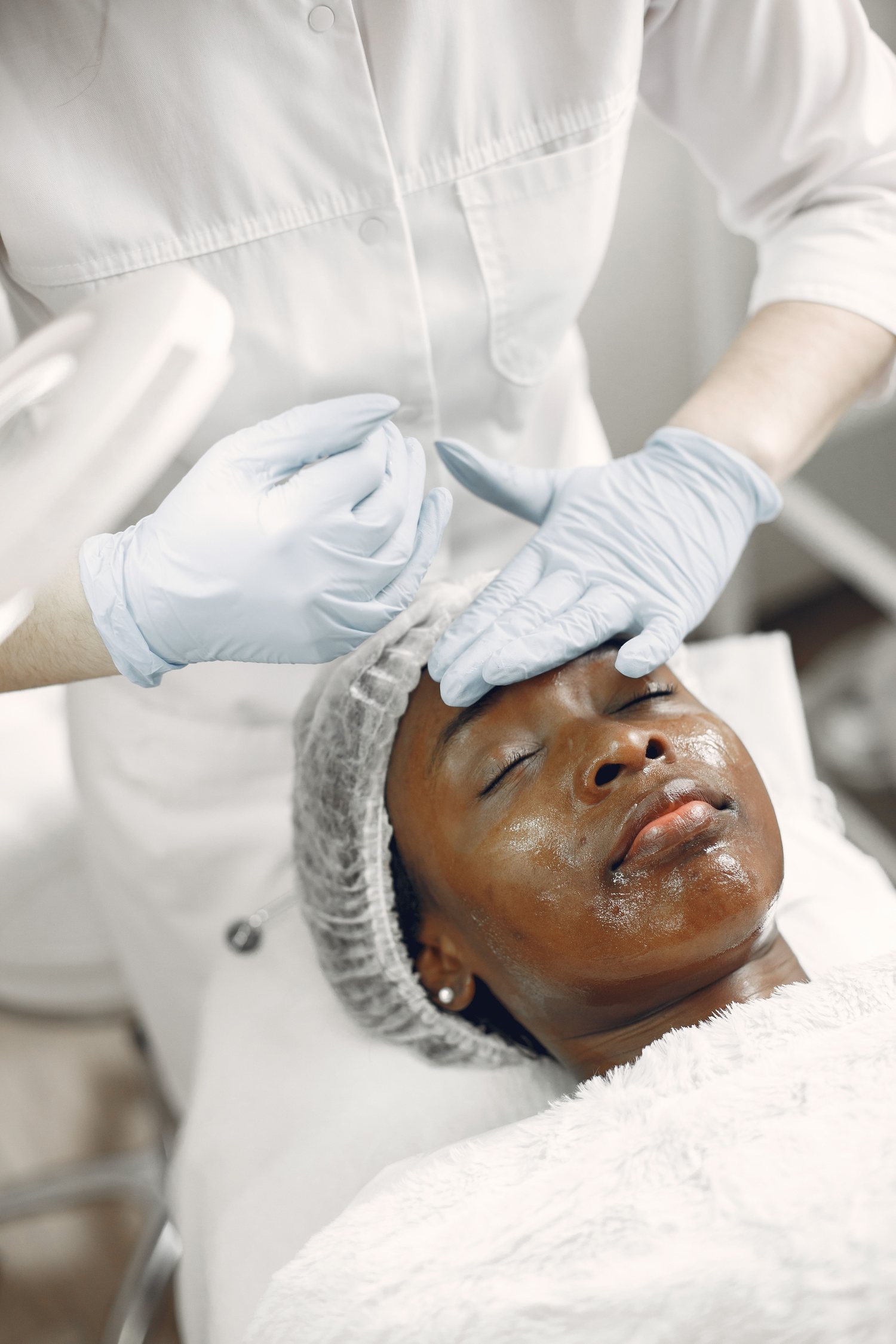 Profissional realizando tratamento facial em clínica de estética
